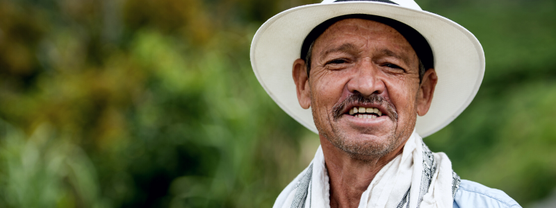 Colombian farmer smiling in traditional attire, embodying the vibrant spirit of Medellín, Colombia - a perfect subject for students learning how to talk in Spanish with Colombia Spanish.