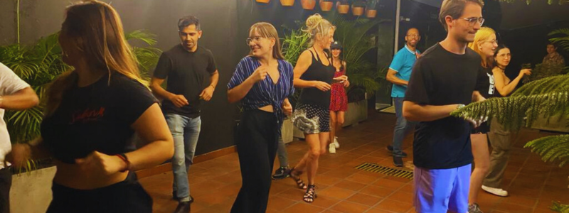Students at a Colombia Spanish school in Medellín enjoying a lively salsa dancing class, embracing the vibrant culture as part of their journey to learn Spanish in Colombia.