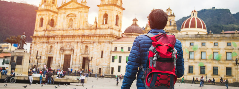 Tourist with backpack marvels at the historic architecture of Bogotá, Colombia, taking the first steps in learning how to speak Spanish, embracing the language and culture of Medellín.
